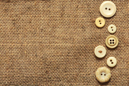 Clothes vintage buttons on burlap texture background with copyspace