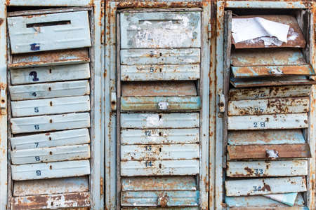 Texture of Old and rusty mailboxes with locks and figures.の写真素材