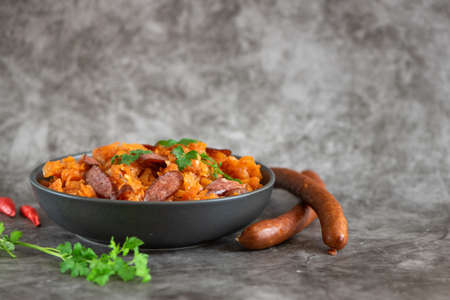 Cabbage stew in bowl with smoked sausages. Side view.の写真素材