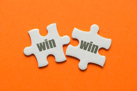 The word win win on two matching puzzle on orange background.の写真素材