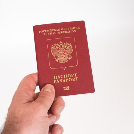 Man's Hand holding Russian international passport isolated on white background.の写真素材