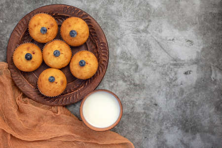 Blueberry muffins with cup of milk on gray background. Top view. With copy space.の写真素材