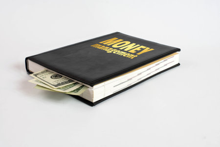 Black book with money and the inscription money management on white background.の写真素材