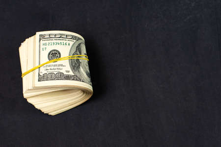 Close Up of Stack of dollars on dark background with copy space.の写真素材