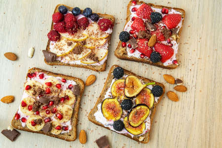 Healthy breakfast. Slices of wholegrain toasts with cream cheese, various fruit, seeds and nuts. Top view. Dieting concept.の写真素材
