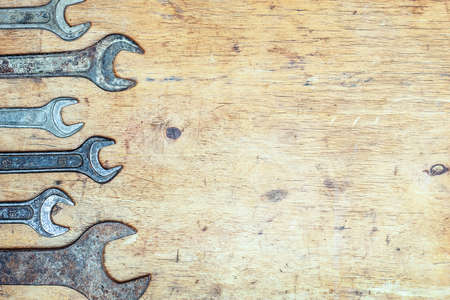Old vintage wrenches on wooden background. Top view. With copy space.の写真素材