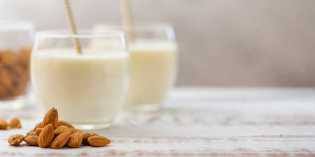 Almond milk in glasses with almond on a light wooden table.の写真素材