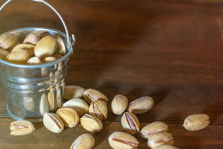 Pistachios on dark wooden background.