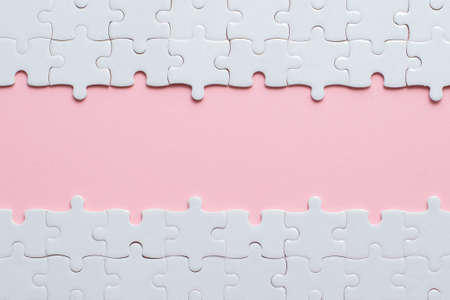 White details of puzzle on pink background and place for inscription.の写真素材