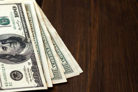 dollar banknotes on dark wooden background with copy space.