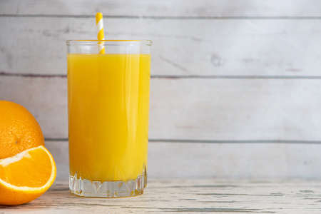Glass of Fresh Orange Juice on light wooden background. Side view. With copy space.の写真素材