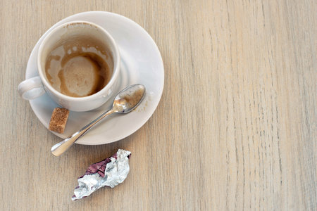 Top view of empty white cup after coffee with some dirty marks, remains of the food and wrapper on the candy.の写真素材