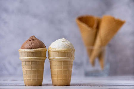 Vanilla and chocolate ice cream. and waffle cones on light background. Side view.の写真素材