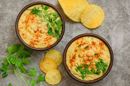 Classic hummus with parsley close-up, chips, top view.の写真素材