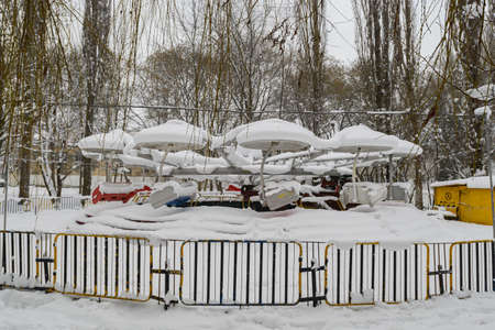 Carousel covered with snow in the park in winter.の写真素材