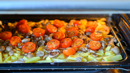 Baked potatoes with mushrooms cherry tomatoes in the oven.の写真素材
