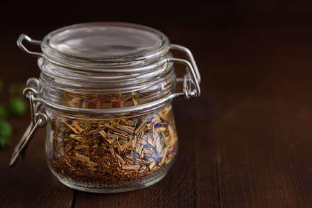 Jar of loose tea leaves on a wooden brown table. copyspace.の写真素材