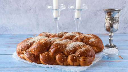 Shabbat Shalom - challah bread, shabbat wine and candles on wooden table. close up. side view.の写真素材