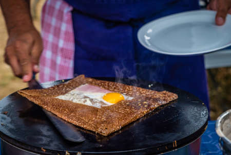French crepe with egg, ham and cheese ready to be put on the plateの写真素材