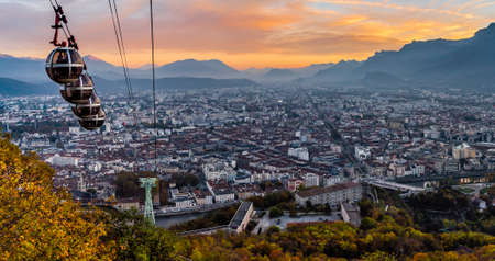 Panorama of Grenoble and its cable cars descending in the sunsetの写真素材