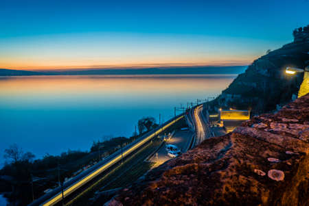 Geneva lake at night just after sunset with light trails on the roadの写真素材