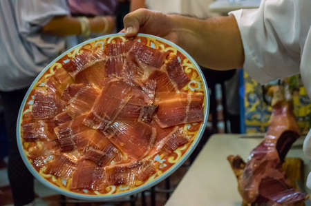Traditional spanish ham in a plate in a restaurant in Sevillaの写真素材