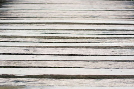 Gray wooden boardwalk weathered with rough textured and mossの写真素材
