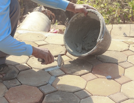 Close-up of men hand holding a trowel, applying mortar の写真素材