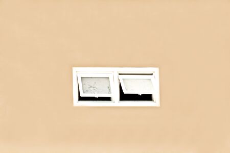 Facing window on the orange wall.