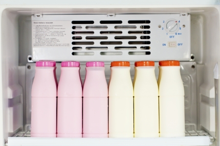 Various bottles of milk in the fridge.の写真素材
