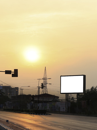 Road with lanterns and large blank billboard at evening in cityの写真素材