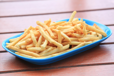 bowl of french fries on wooden table.