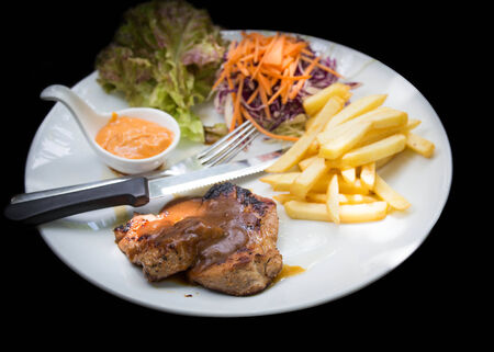 juicy grilled pork chop (neck cut) with greens.の写真素材