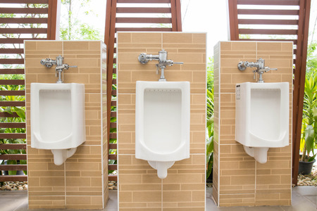 White urinals with ceramic tile on wall