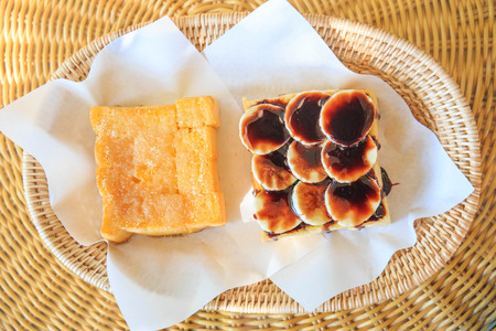 Baked bread buttered and bread chocolate on bamboo plate