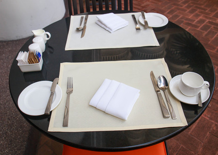 View of a coffee terrace with tables and chairs .