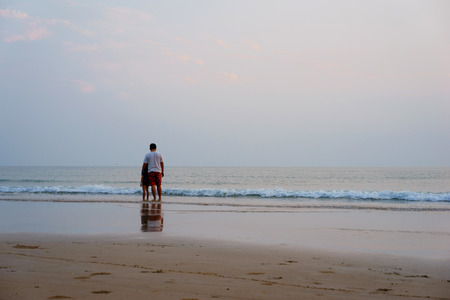 father and daughter standing at the beach.の写真素材