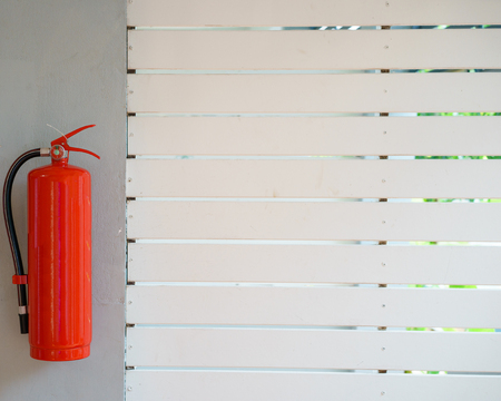 Fire extinguisher in front of room at apartmentの写真素材