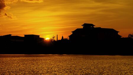Silhouette of city buildings as the sun sets, represents a new beginningの写真素材