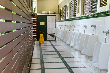 row white urinals in men's bathroom toilet.の写真素材
