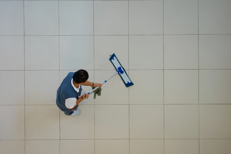 Woman cleaning floor at department store. View from above. Selective focus.の写真素材