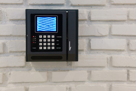 Modern bank terminal on a brick wall.