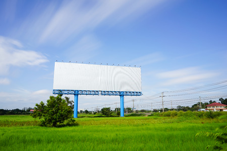 Blank billboard for advetising at rice field with moving cloud on blue sky.の写真素材