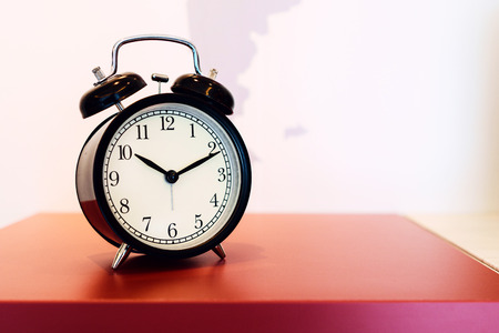 Vintage background with retro alarm clock on table.