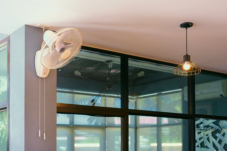 Electric fan hanging on wall,vintage style.の写真素材