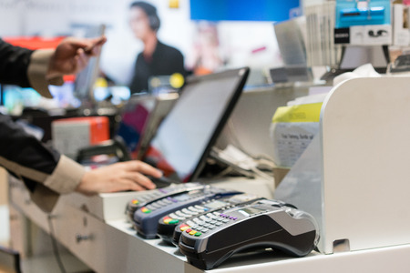 Man using pos terminal at the shop (paying credit card for purchases).の写真素材