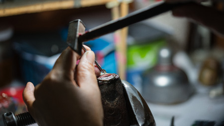 Close up of a jeweler's hands doing a repairの写真素材
