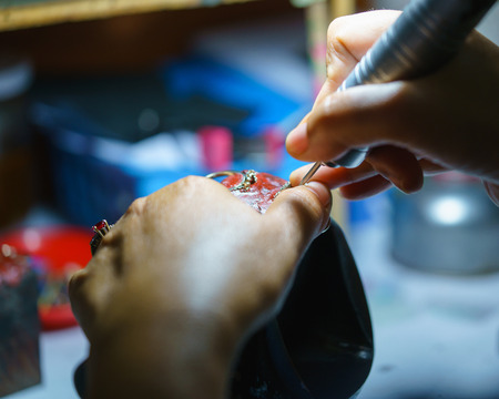 Close up of a jeweler's hands doing a repairの写真素材