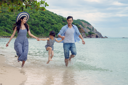 Happy family playing on the beach at the day timeの写真素材
