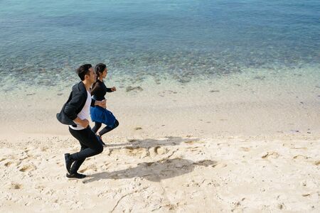 Couple jogging along the beachの写真素材